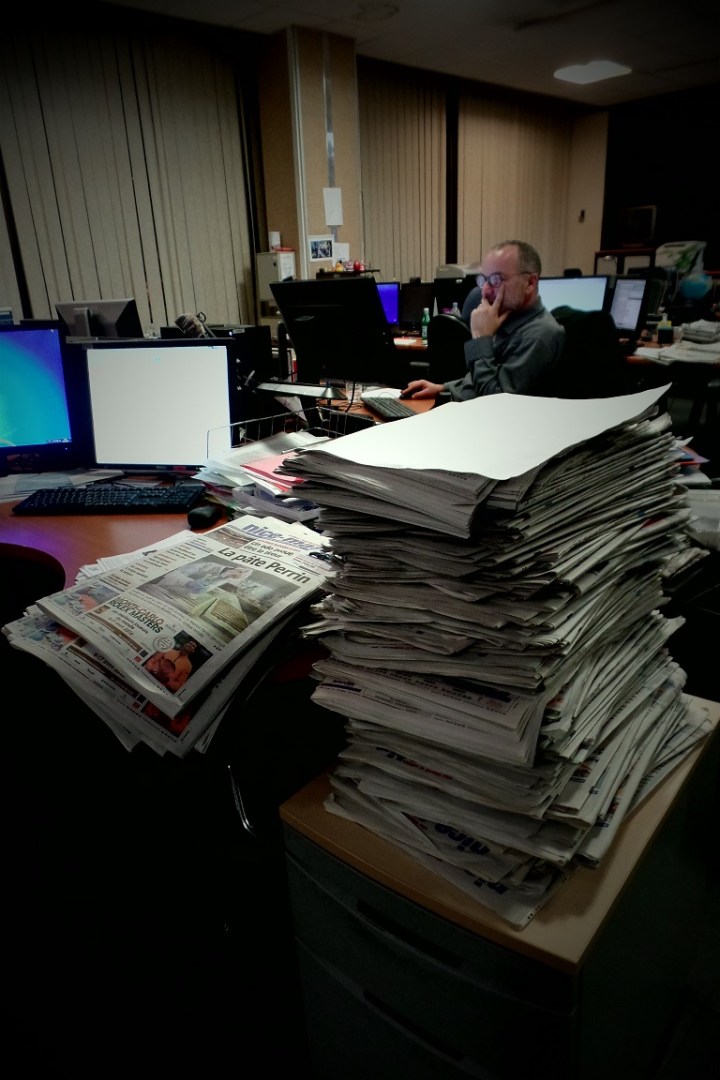 Pile de journaux sur les bureaux des journalistes qui apportent les dernières touches à l’édition du 27 février 2016. Crédit photo Elsa Hellemans