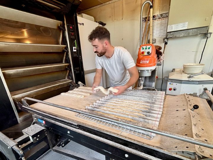 Eliott Philippe enfourne les baguettes traditions. Il en fait cuire dès qu’il en manque pour
s’assurer que ses clients aient du pain chaud et frais, toute la journée.